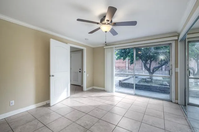 a view of an empty room and window a ceiling fan