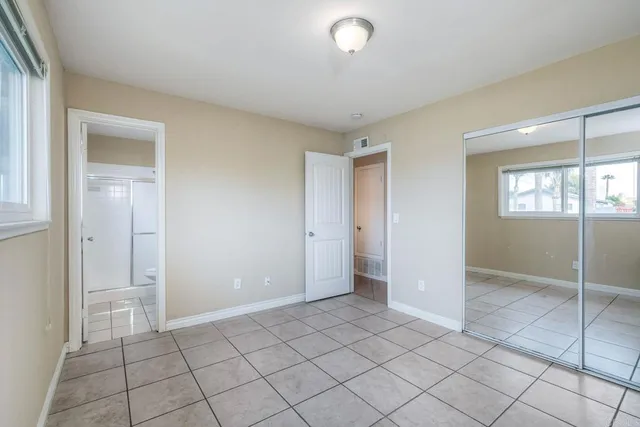an empty room with fan and windows