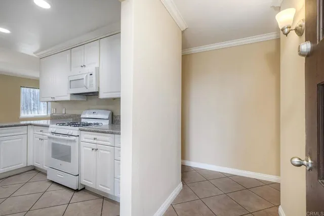 a kitchen with white cabinets and white appliances