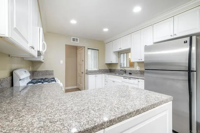 a kitchen with refrigerator cabinets and a sink