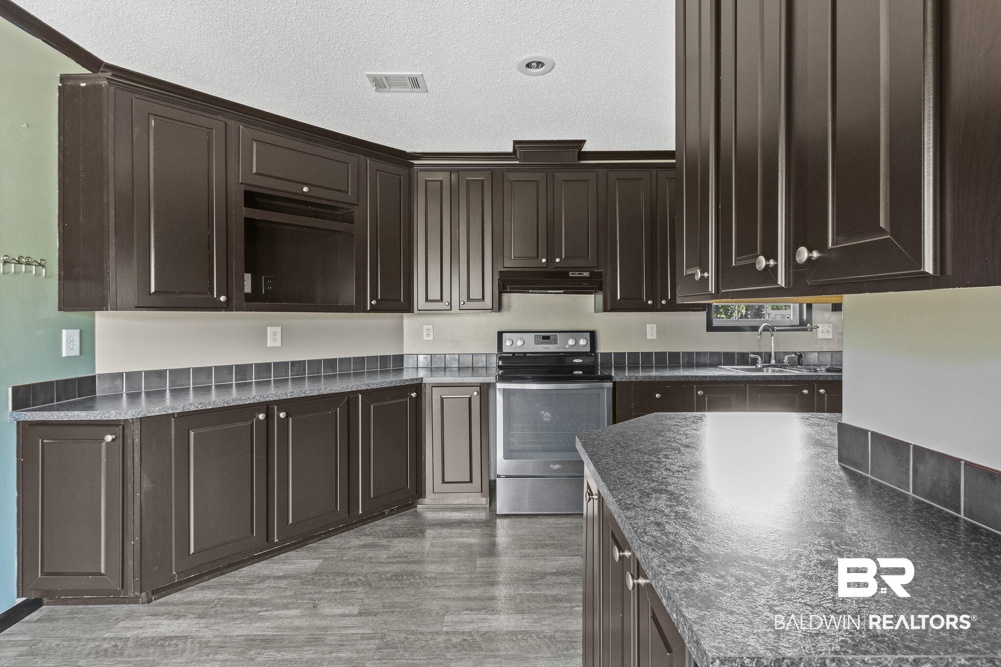 6870 Cecilia Court Theodore, AL 36582 - Photo 19 of 83 Kitchen with sink, dark brown cabinets, a textured ceiling, stainless steel electric stove, and light hardwood / wood-style floors