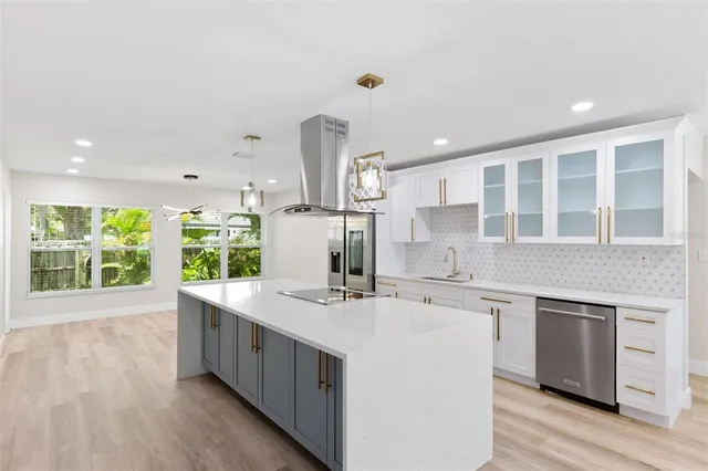 a large white kitchen with a large window