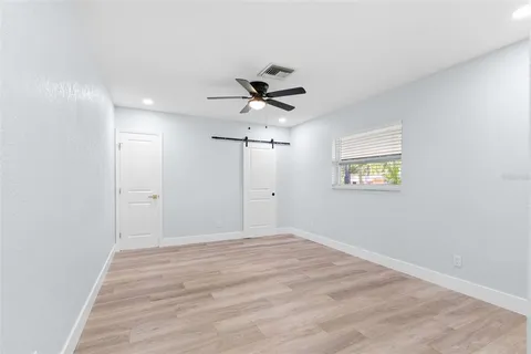 a view of a big room with wooden floor and ceiling fan