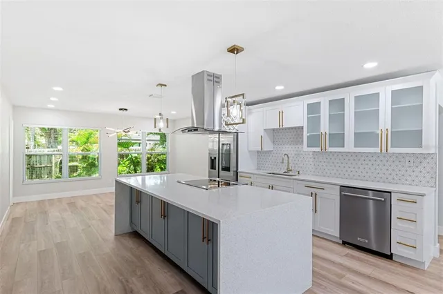 a kitchen with kitchen island granite countertop a sink stove and wooden cabinets