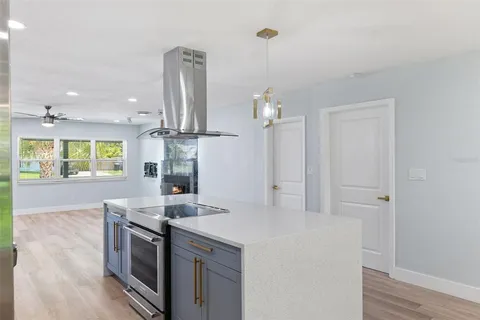 a kitchen with stainless steel appliances granite countertop a sink a stove and a wooden floors