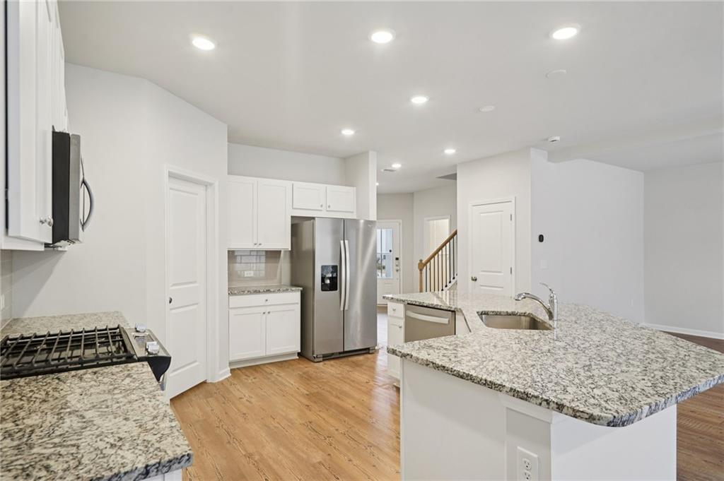2101 Ecoland Drive Grayson, GA 30017 - Photo 9 of 26 a kitchen with stainless steel appliances granite countertop a sink stove and refrigerator