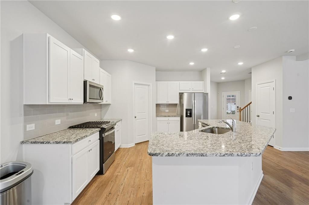 2101 Ecoland Drive Grayson, GA 30017 - Photo 10 of 26 a kitchen with stainless steel appliances granite countertop a sink stove and refrigerator