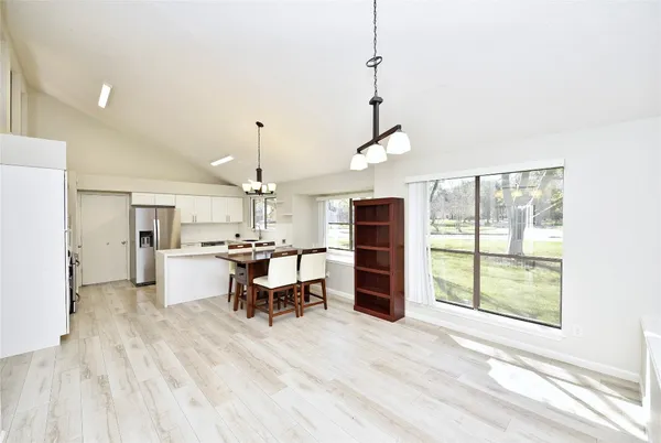 a view of a kitchen with dining area wooden floor and appliances