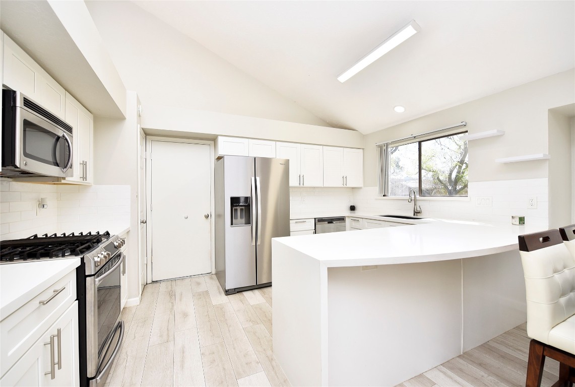 3203 East Rangecrest Place Sugar Land, TX 77479 - Photo 13 of 36 a kitchen with stainless steel appliances a sink a stove a refrigerator and cabinets