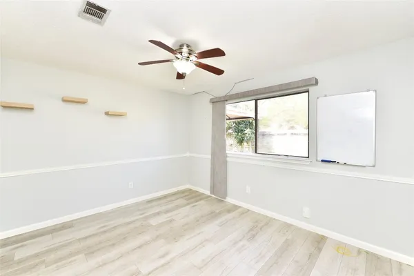 a view of empty room with window and wooden floor