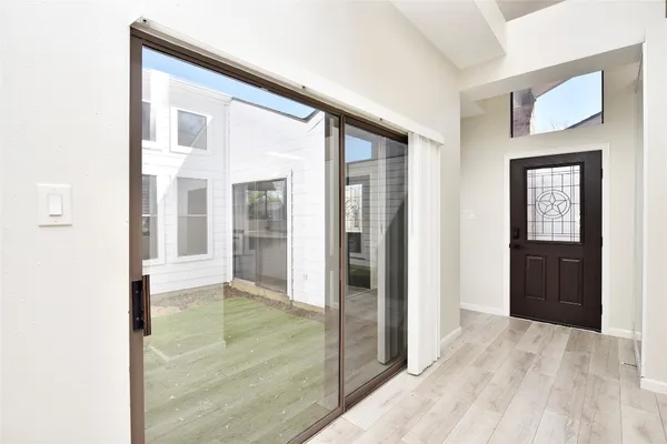 a view of a hallway with wooden floor and a living room