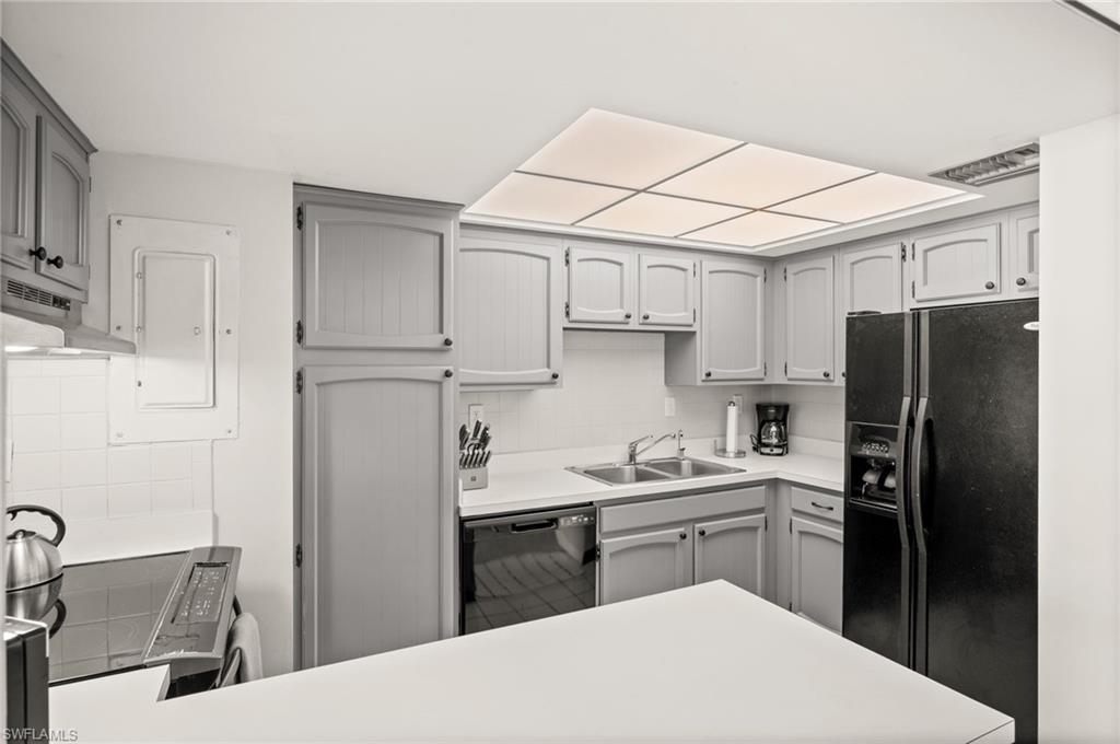 Undisclosed Address Naples, FL 34103 - Photo 6 of 24 a kitchen with a sink a refrigerator and cabinets