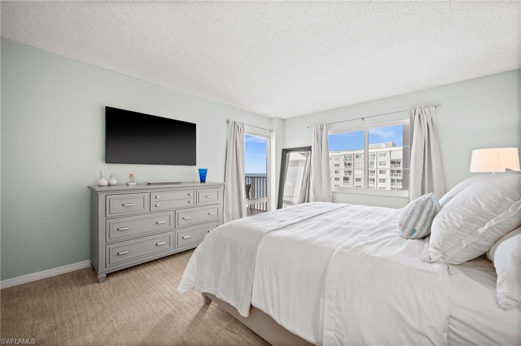 Undisclosed Address Naples, FL 34103 - Photo 8 of 24 a bedroom with a bed and a flat screen tv in it