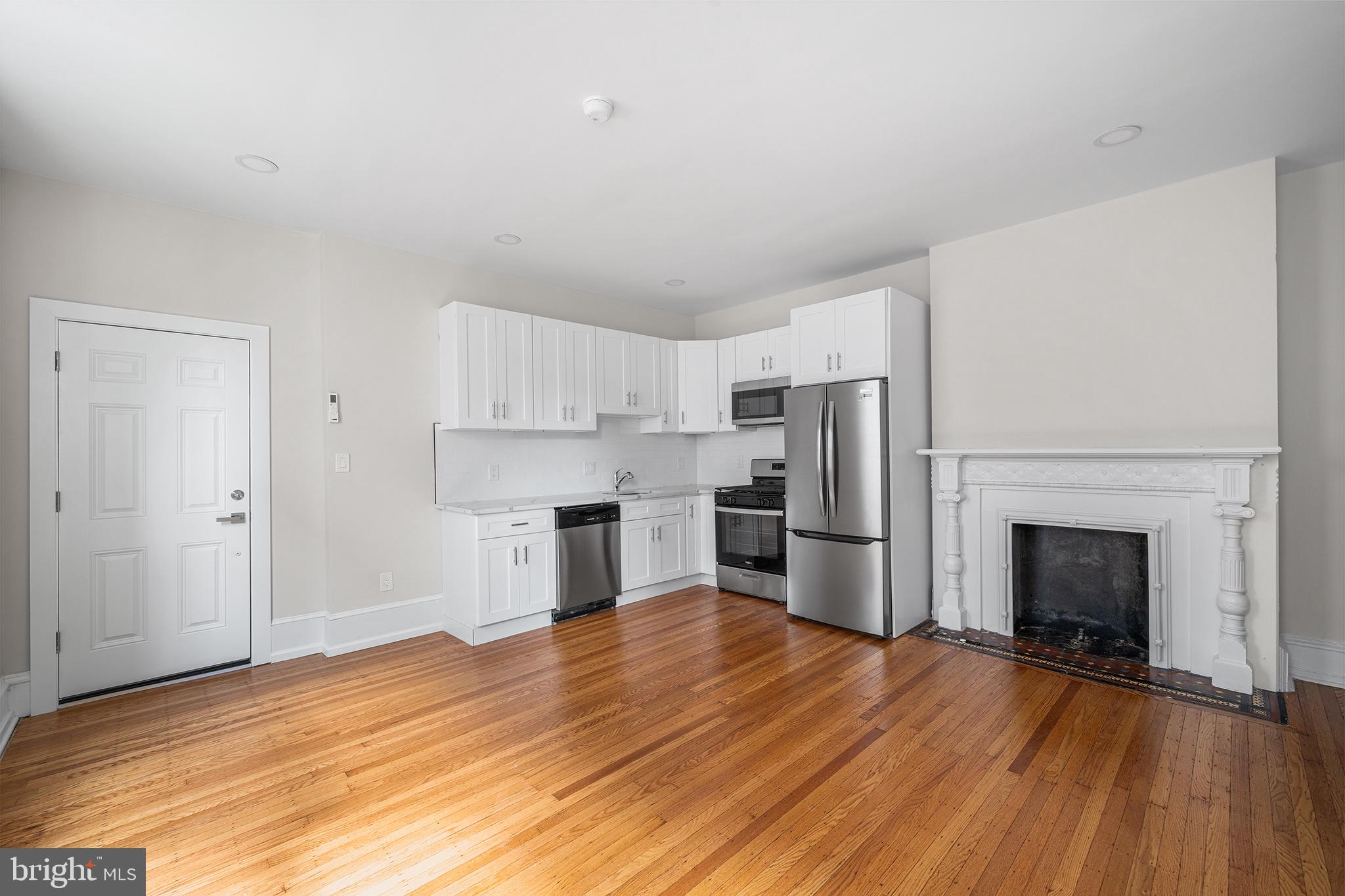 2309 Green Street, Unit 2R Philadelphia, PA 19130 - Photo 2 of 15 a kitchen with granite countertop a refrigerator and a stove top oven