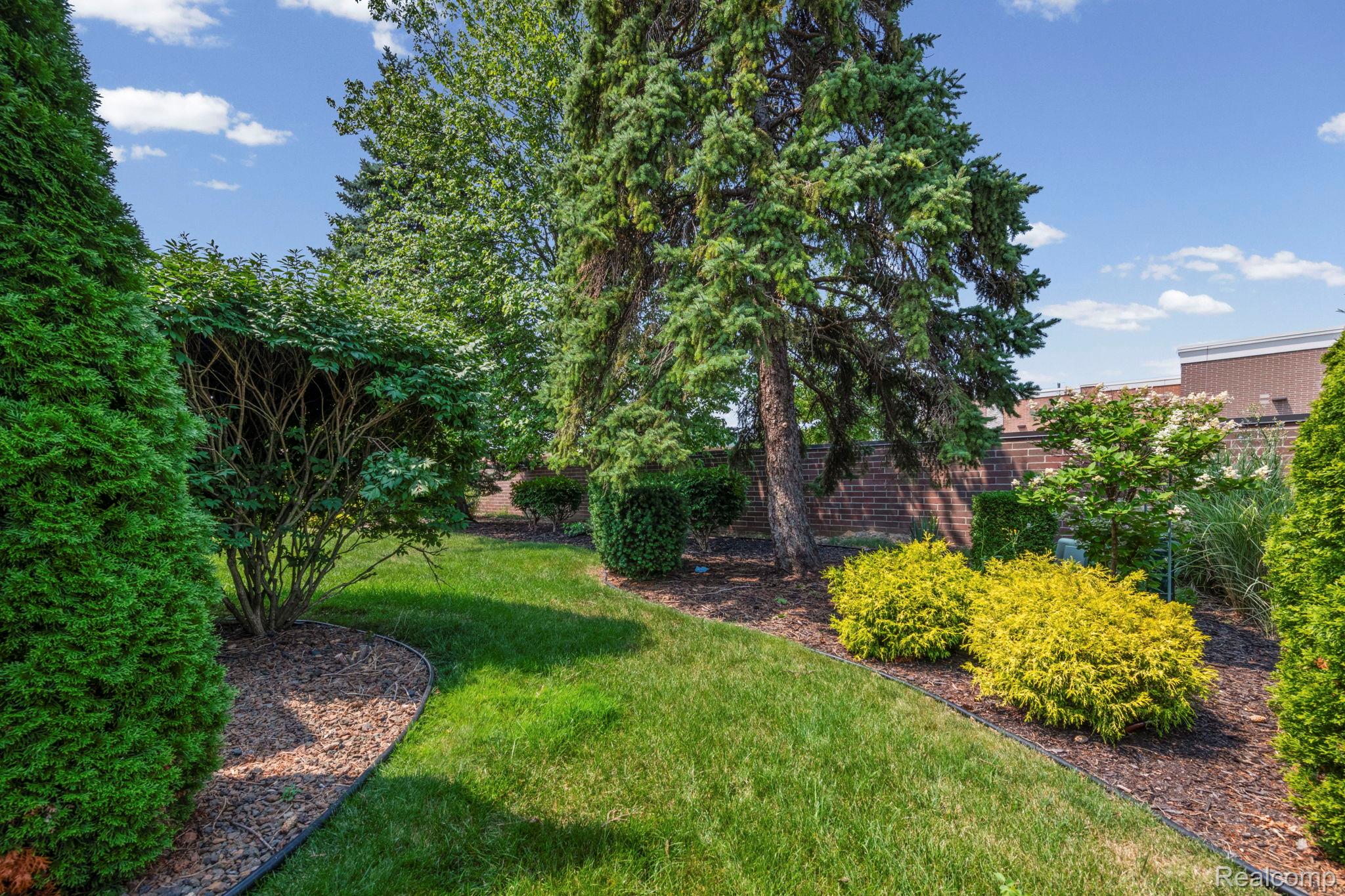 21580 Georgetown Road Trenton, MI 48183 - Photo 34 of 36 Expansive landscaped grounds featuring mature evergreen trees, manicured shrubs, and a lush green lawn