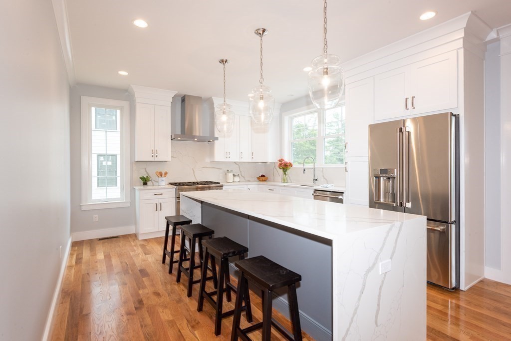 103 Francis Wyman Road Burlington, MA 01803 - Photo 4 of 42 a kitchen with stainless steel appliances granite countertop a refrigerator a sink dishwasher a stove a dining table and chairs with wooden floor