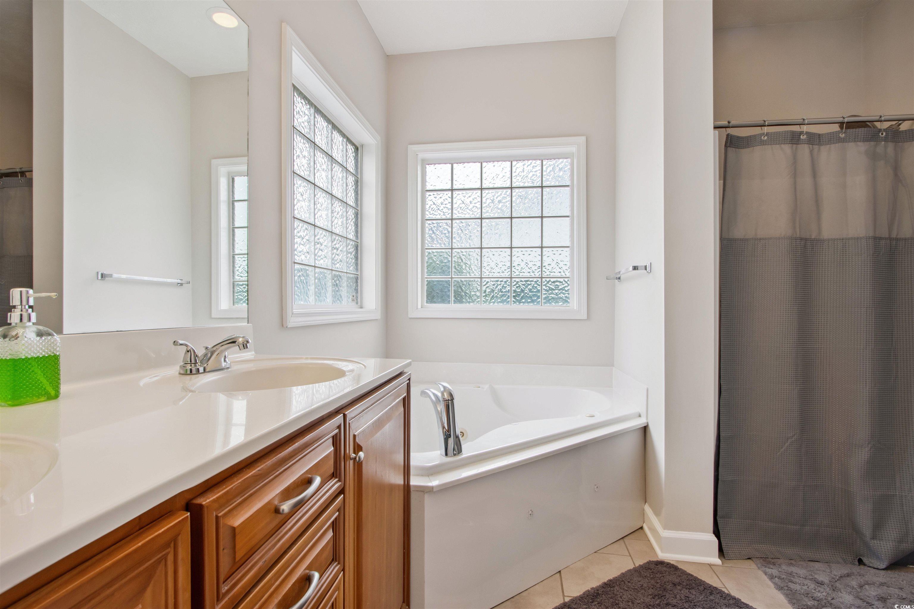 Undisclosed Address Conway, SC 29526 - Photo 13 of 26 Bathroom featuring double vanity, tile patterned floors, a bath, and a shower with curtain