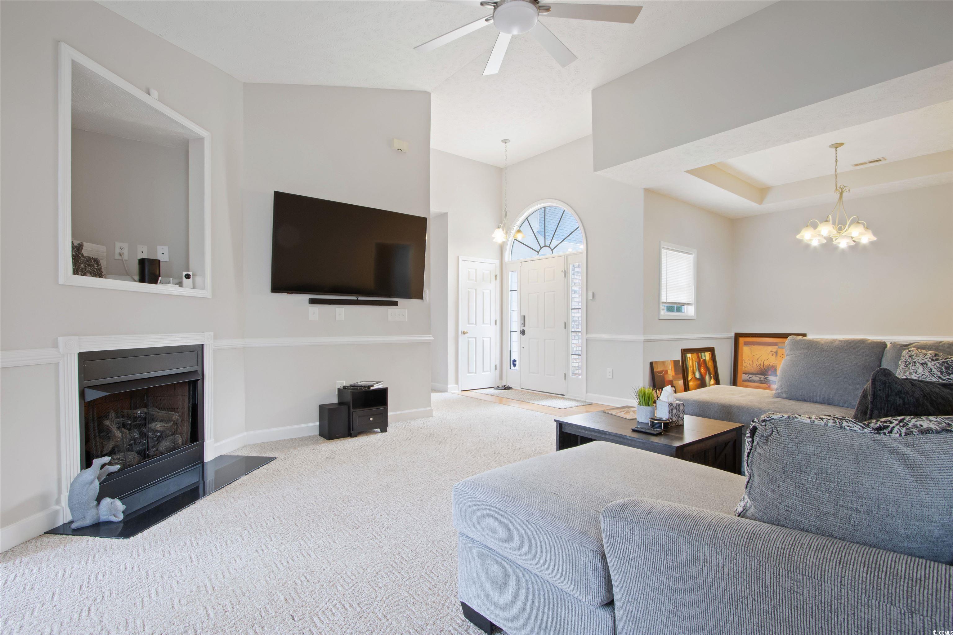 Undisclosed Address Conway, SC 29526 - Photo 6 of 26 Living area with carpet flooring, a chandelier, a fireplace, and a ceiling fan