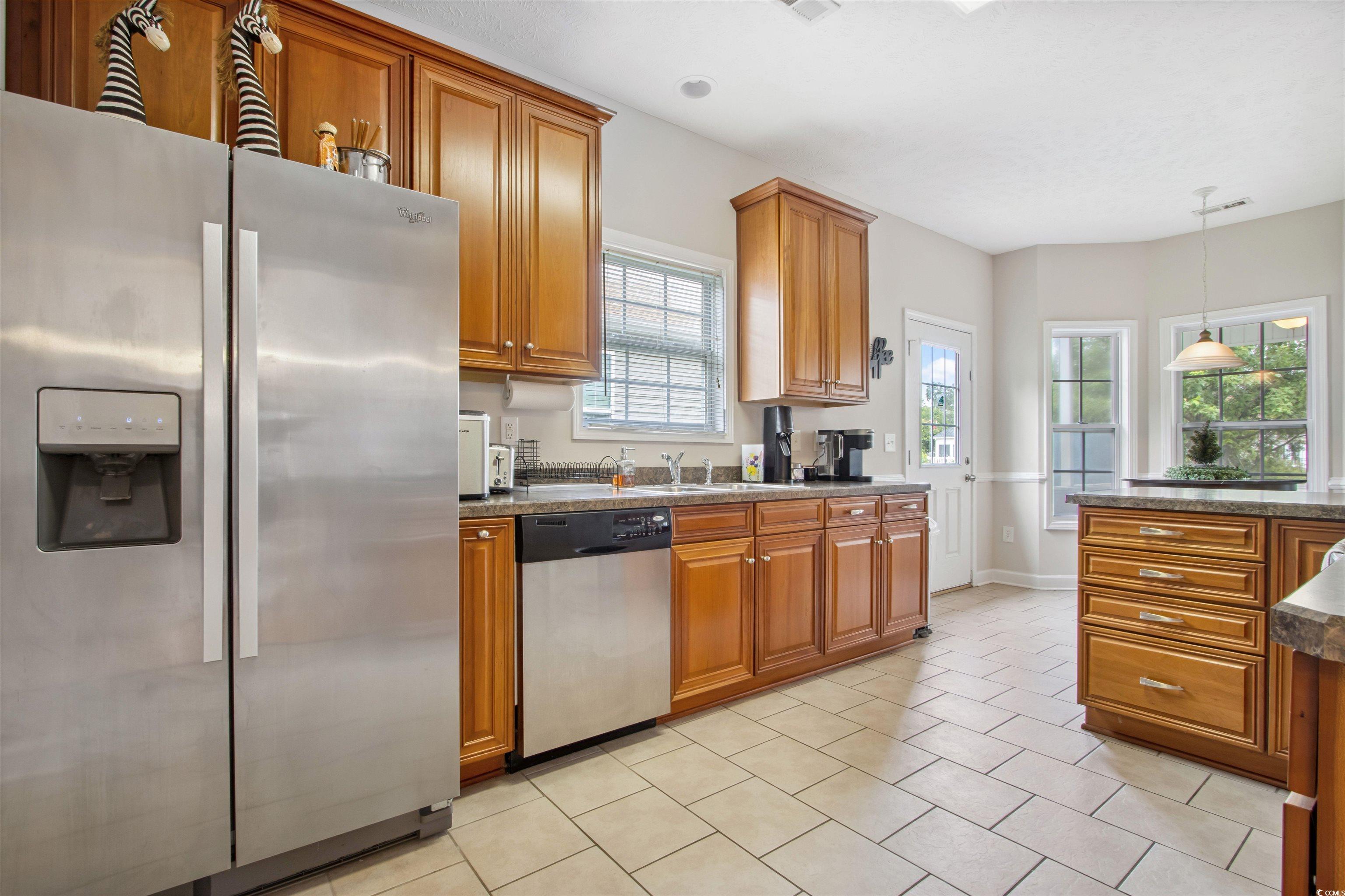 Undisclosed Address Conway, SC 29526 - Photo 7 of 26 Kitchen featuring appliances with stainless steel finishes, brown cabinets, and plenty of natural light