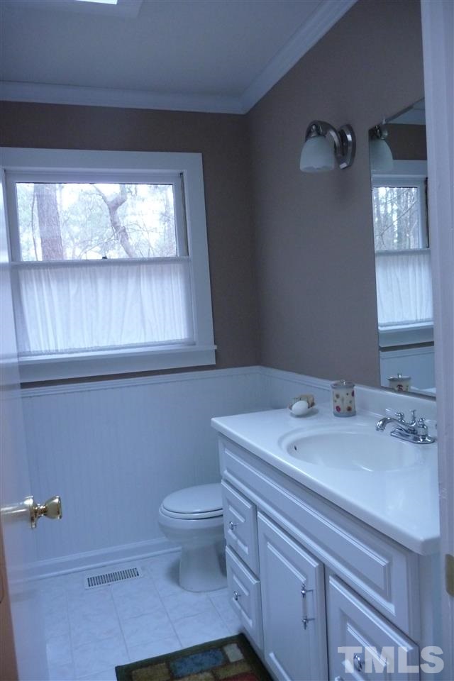 8705 Brandon Station Road Raleigh, NC 27613 - Photo 11 of 16 a bathroom with a sink a toilet and window
