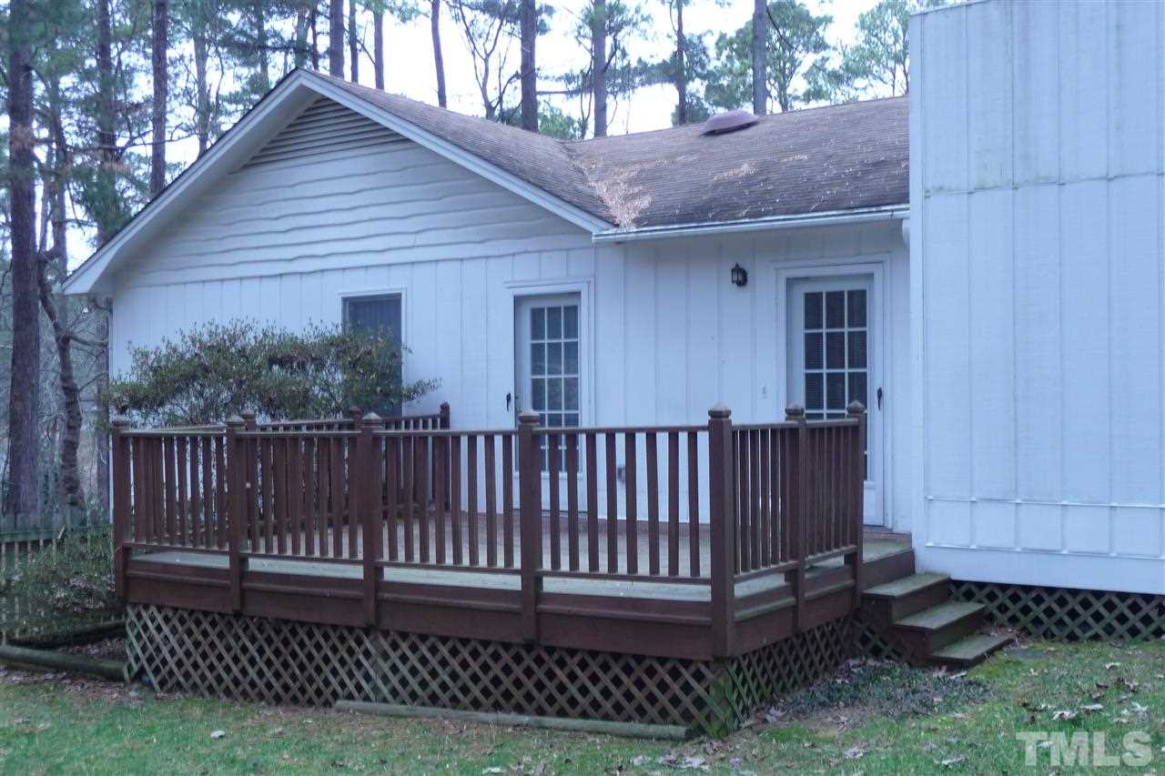 8705 Brandon Station Road Raleigh, NC 27613 - Photo 13 of 16 a view of a house with a small yard and wooden fence