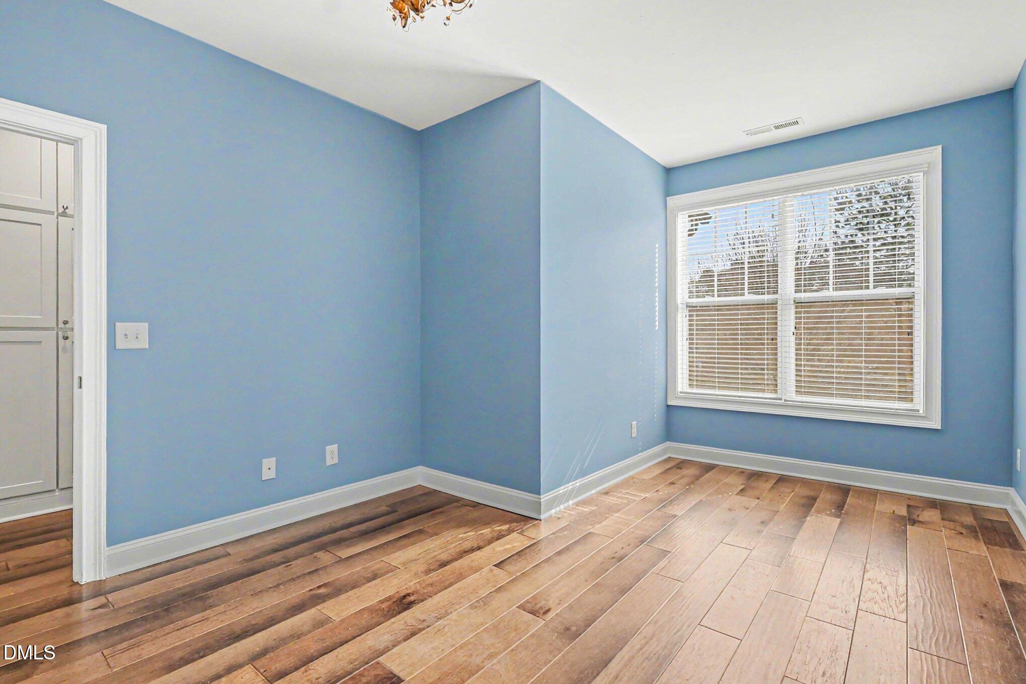 653 Fallon Grove Way Raleigh, NC 27608 - Photo 15 of 38 a view of an empty room with wooden floor and a window