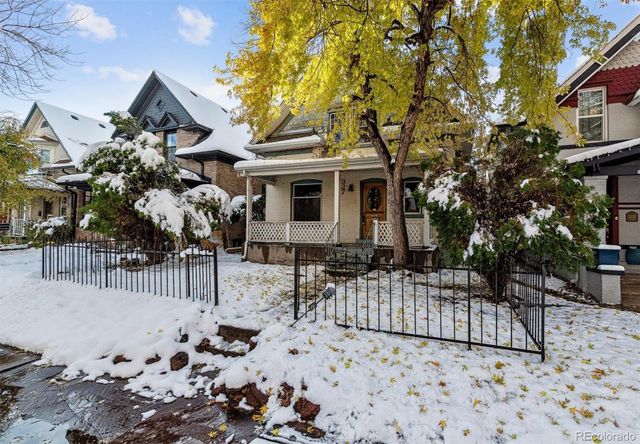 a front view of a house with a tree