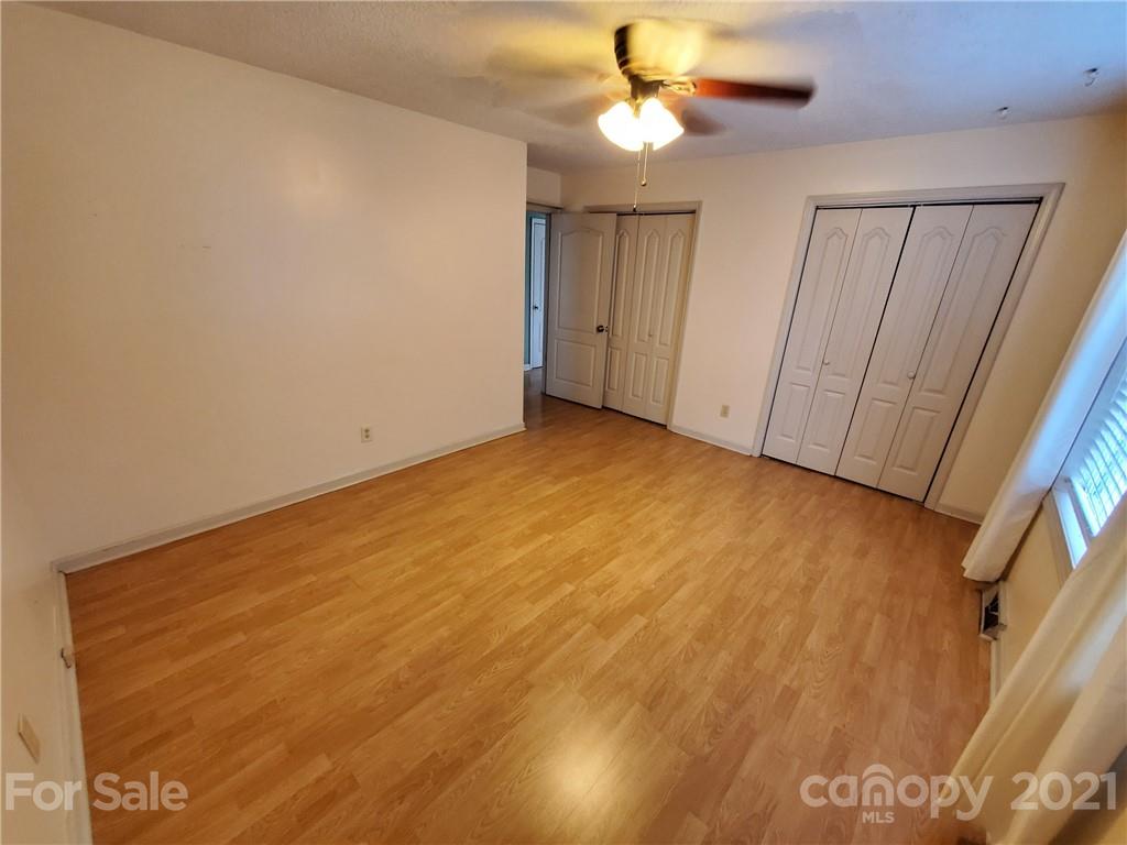 175 Old Airport Road Statesville, NC 28677 - Photo 4 of 15 an empty room with a ceiling fan and wooden floor
