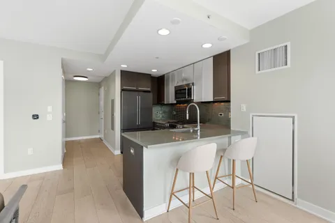 a view of a kitchen with a refrigerator and a sink