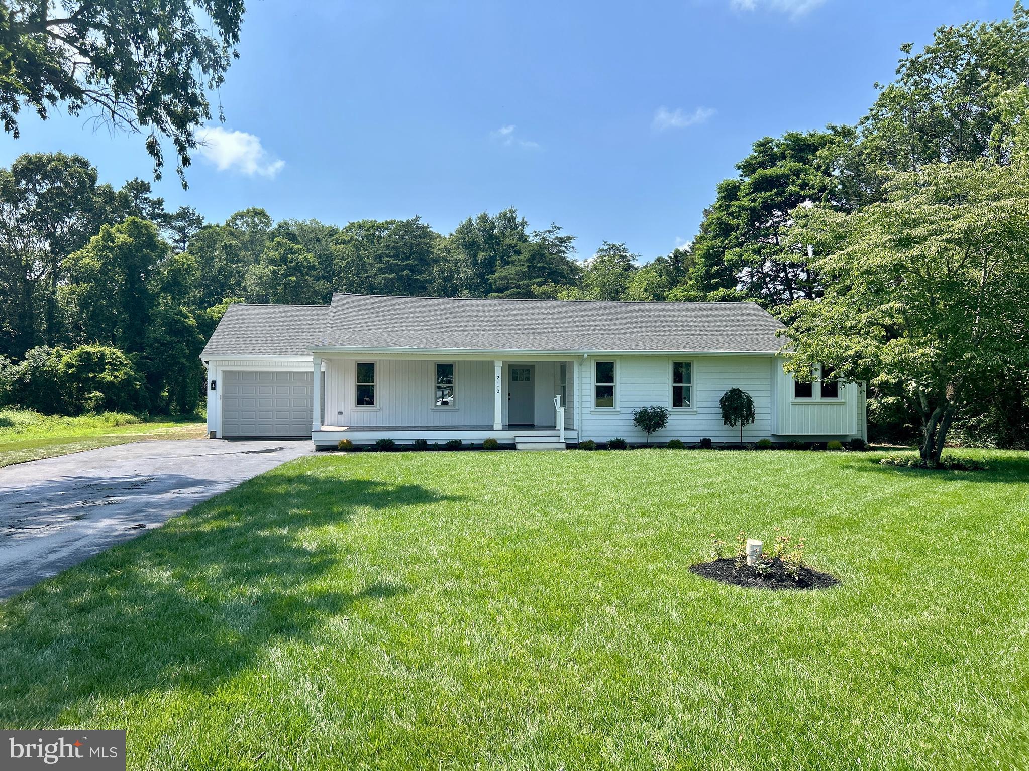 a front view of house with a garden and deck