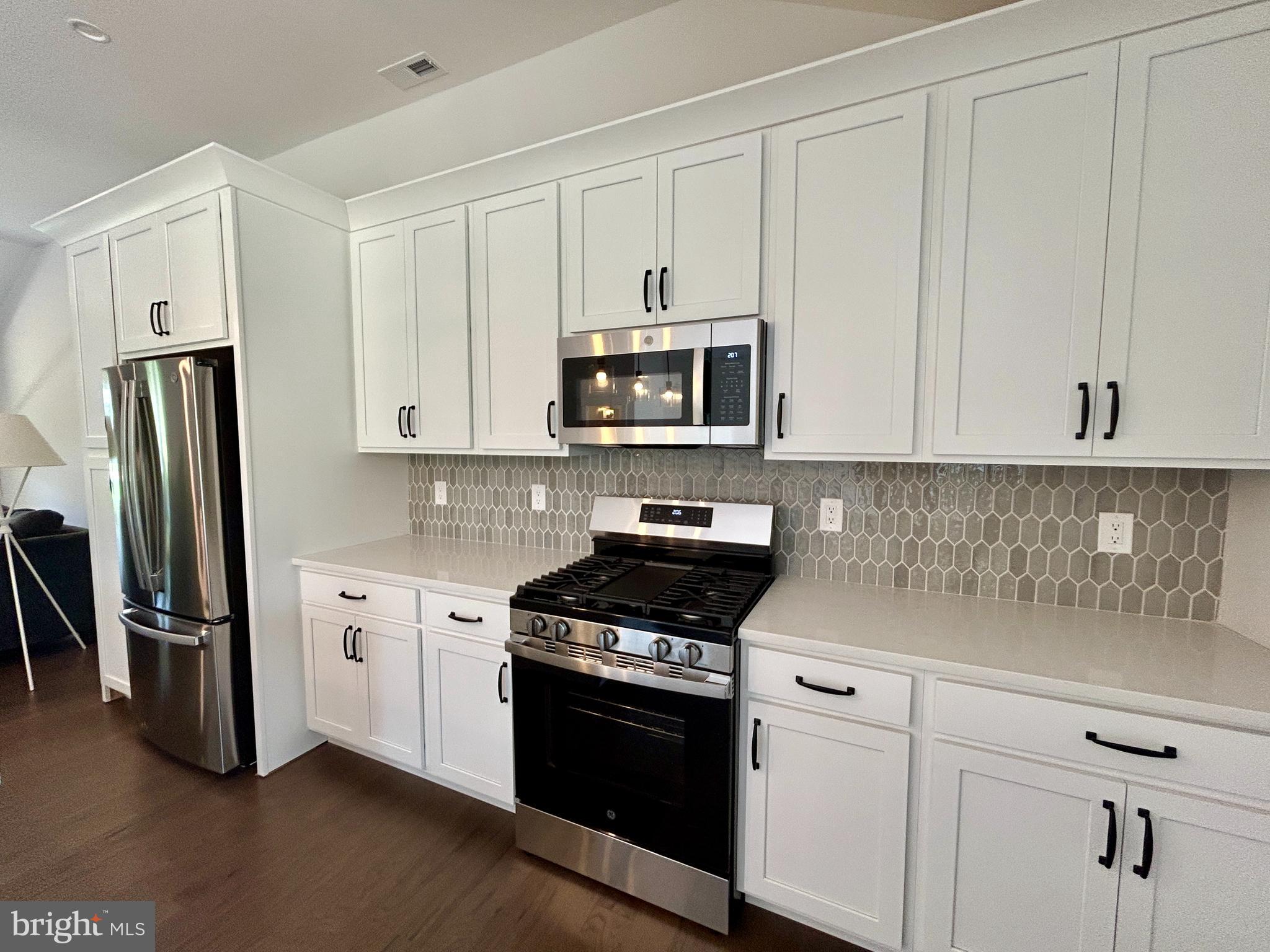 210 Perry Road Woodbine, NJ 08270 - Photo 22 of 35 a kitchen with granite countertop white cabinets and stainless steel appliances