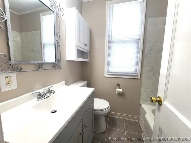 a bathroom with a sink toilet vanity and window