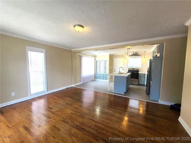 a view of a big room with wooden floor and windows