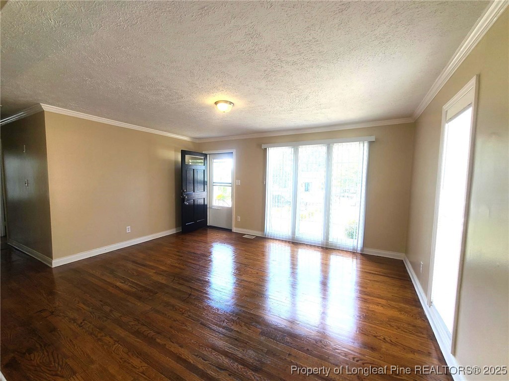512 Spaulding Street Fayetteville, NC 28301 - Photo 5 of 19 a view of an empty room with wooden floor and a window
