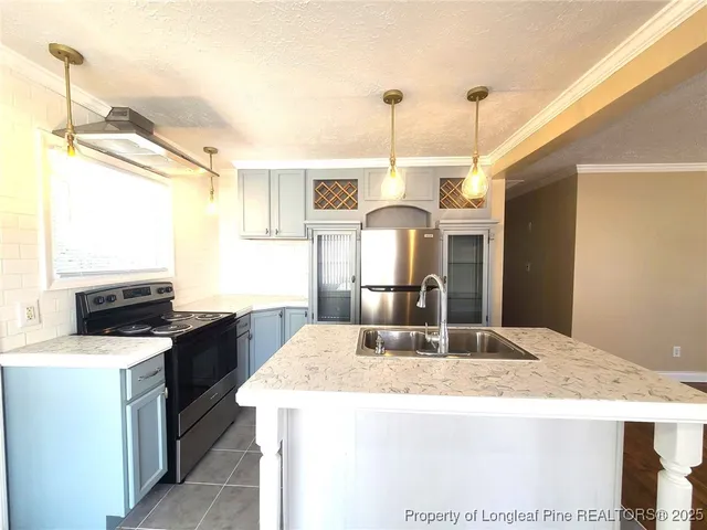 a kitchen with a stove a sink a refrigerator and a dining table