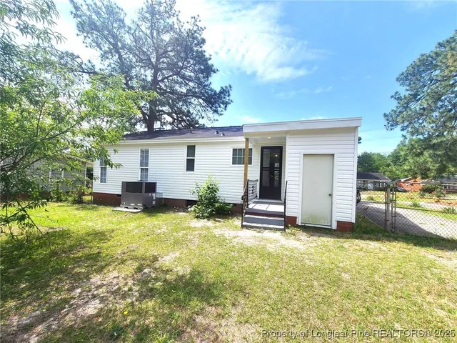 a view of a house with a patio and a yard