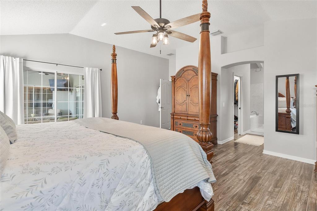 1027 Urico Road Lady Lake, FL 32159 - Photo 21 of 49 a bedroom with a bed a ceiling fan and a wooden floor