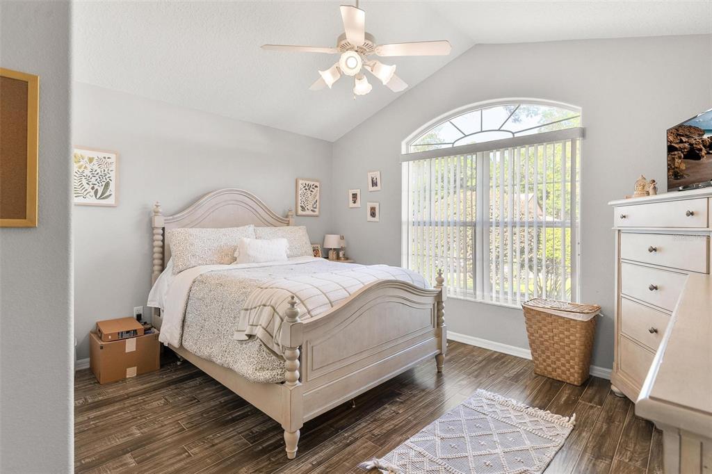 1027 Urico Road Lady Lake, FL 32159 - Photo 29 of 49 a bedroom with a large bed and a chandelier