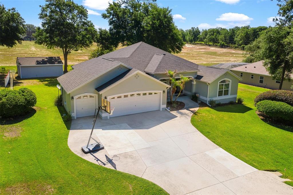 1027 Urico Road Lady Lake, FL 32159 - Photo 45 of 49 a view of a house with a yard and a car park fire pit