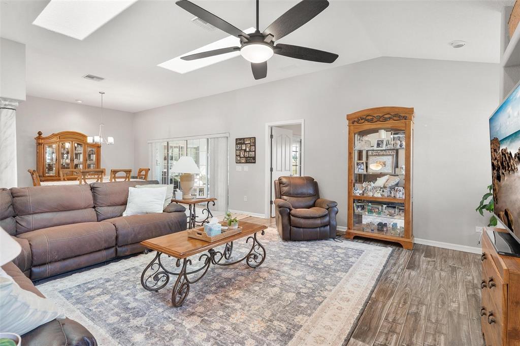 1027 Urico Road Lady Lake, FL 32159 - Photo 8 of 49 a living room with furniture a wooden floor and a ceiling fan