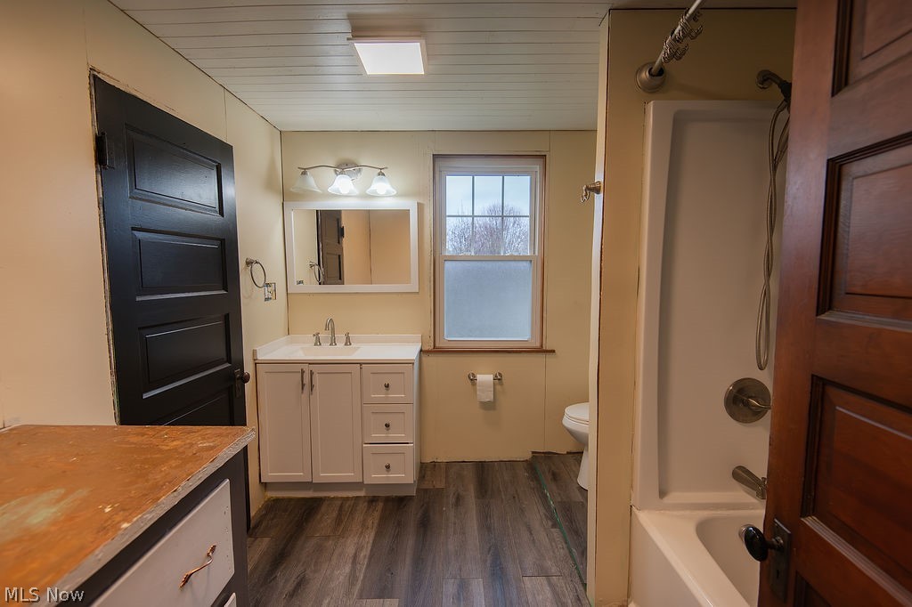 1195 South Johnson Road Sebring, OH 44672 - Photo 24 of 34 Bathroom featuring vanity, wood ceiling, dark wood-style floors, and shower combination