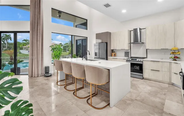 a large white kitchen with a large window and sink