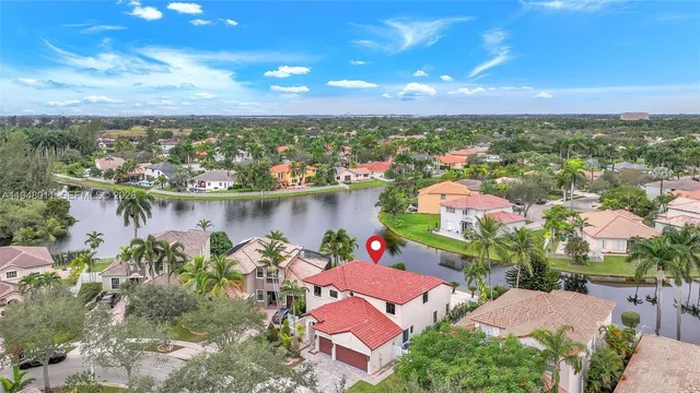 an aerial view of residential houses with outdoor space and lake view