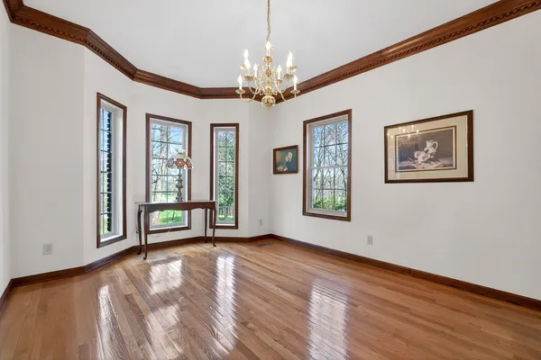 a view of an empty room with window and wooden floor