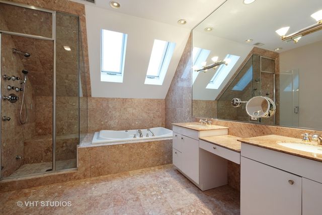 a bathroom with a granite countertop bathtub sink vanity and mirror