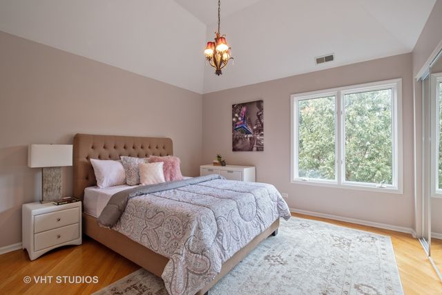 a spacious bedroom with a bed and a chandelier
