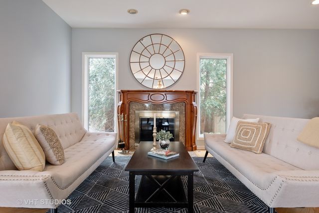 a living room with furniture a fireplace and a large window