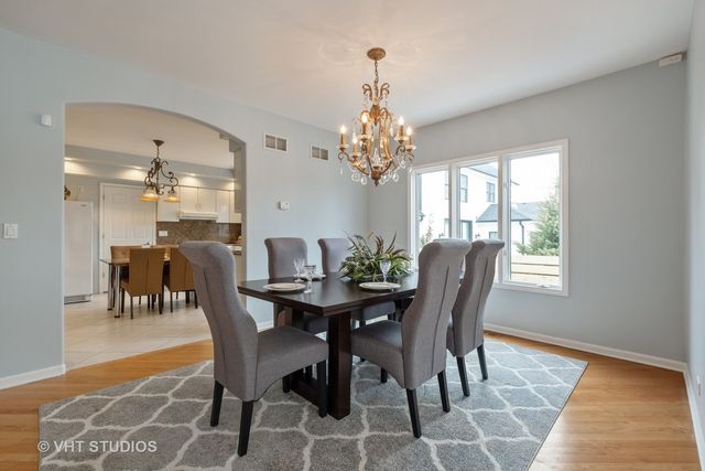 a dining room with furniture a chandelier and window
