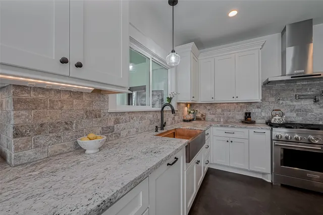 a kitchen with stainless steel appliances granite countertop a sink stove and cabinets