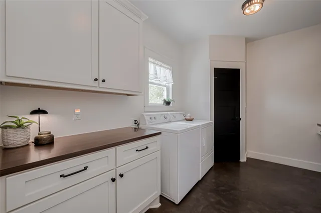 a kitchen with white cabinets and sink